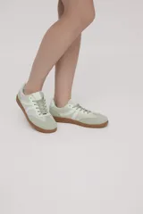 Zapatillas Adidas Samba color verde claro con detalles en blanco y suela de goma color caramelo.