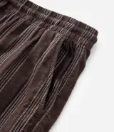 Bermuda masculina de corte recto confeccionada en tejido jacquard con textura y estampado de rayas verticales en tonos marrones. Cuenta con cintura elástica con cordón ajustable y bolsillos laterales.