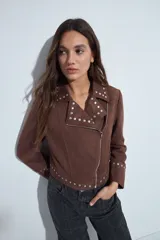 Campera estilo biker de símil gamuza color marrón, con cierre frontal y detalles de tachas metálicas en solapas, mangas y ruedo.