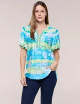 Blusa de rayón en tonos turquesa y verde, con cuello en V con detalles bordados, mangas cortas amplias y diseño estampado con motivos florales y geométricos.