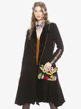 Saco largo de estilo bohemio confeccionado en algodón con efecto lavado. Presenta cuello y solapas de terciopelo, cierre frontal con botones, espalda superior con tejido jacquard floral y puños de punto con aplicaciones florales bordadas. Incluye dos bolsillos laterales.