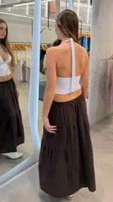 Pollera larga de color marrón chocolate, con diseño de volados en capas y cintura elástica.