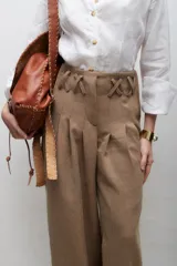 Pantalón de vestir azul eléctrico con pinzas, tiro alto, corte ancho y cinturón marrón con hebilla metálica con forma de sol.