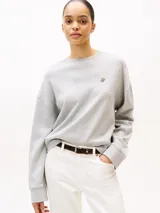 Buzo gris de cuello redondo, confeccionado en modal sostenible y algodón regenerativo, con logo Tommy Hilfiger script bordado en el pecho.