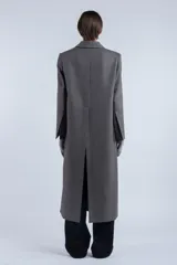 Tapado largo de lana virgen con motivo pied de poule, cuello con solapa y cierre frontal con tres botones.