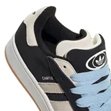 Championes Adidas modelo Campus 00s, de diseño robusto inspirado en el skate. Presentan una base de gamuza negra con las icónicas tres tiras laterales y refuerzo en el talón en color gris claro. Incluyen cordones gruesos en color celeste, entresuela blanca y suela de goma color caramelo.