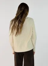 Sweater de tejido de punto acanalado en color marrón oscuro, con cuello alto y mangas largas con corte raglán.