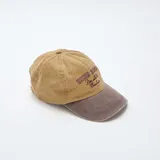 Gorra de béisbol con diseño bicolor, cuerpo en color tostado y visera en color marrón oscuro. Presenta un bordado frontal con el texto 'ECHO RIDGE Rise with the Mountain'.