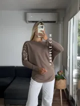 Sweater color marrón de manga murciélago oversize, con escote barco y bordado de lentejuelas y canutillos al tono en hombros y mangas.