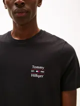 Remera de cuello redondo y manga corta, confeccionada en puro algodón. Presenta un diseño de corte regular con un pequeño logo de Tommy Hilfiger bordado en el pecho.