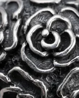 Anillo de plata 925 con diseño de flores en bajo relieve y acabado empavonado.