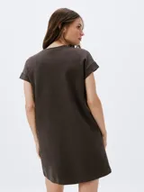 Vestido corto negro de manga corta, con corte recto, escote redondo y un bolsillo aplicado en el pecho.