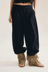 Pantalon balloon color negro, de tiro alto con cintura elastizada, corte amplio y volumen bombacho que se angosta hacia los tobillos.