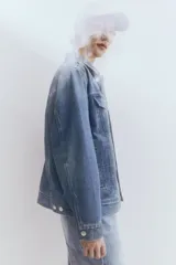 Campera de denim celeste con cuello clásico, cierre frontal con botones metálicos, bolsillos con solapa en el pecho y bolsillos laterales. Corte holgado.