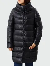 Campera larga de nylon color beige, con relleno de plumas, cuello alto y cierre frontal con broches a presión. Modelo Dora de Herno.