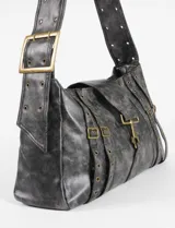 Cartera de hombro de cuero vegano con efecto gastado, color marrón. Presenta un diseño con correas decorativas verticales, hebillas metálicas y ojales, además de un cierre central con mosquetón metálico.