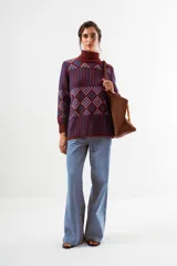 Sweater de cuello alto con diseño de tejido jacquard en tonos marrones y negros, con patrón geométrico y de rayas verticales, de manga larga con puños acanalados.