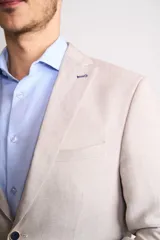 Blazer sport de corte entallado en color celeste, con solapas clásicas, cierre frontal de un botón y bolsillos laterales con solapa. Presenta un pañuelo de bolsillo estampado y botones decorativos en los puños.