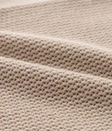 Camisa de punto de manga corta en color beige, con cuello inglés y cierre frontal de botones. Presenta una textura tejida y un corte regular que ofrece un ajuste cómodo y clásico.