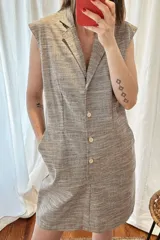 Vestido corto de lino y algodón color tostado, sin mangas, con cuello solapa y cierre frontal de botones.