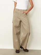 Pantalón tipo jean de corte recto y tiro medio, con estampado de cuadros en tonos beige y marrón. Cuenta con cierre frontal, bolsillos laterales y trabillas para cinturón.