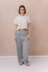 Pantalón de pierna ancha y calce relajado, color gris, con cintura elástica y cordón ajustable blanco.
