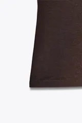 Top blanco de manga sisa con cuello redondo y corte ajustado al cuerpo.