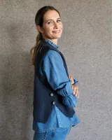 Chaleco de punto en lana lambswool, con cuello redondo y diseño acanalado. Presenta aberturas laterales y cierre con botones en los costados.