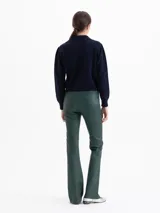 Pantalón de cuero ovino elastizado en color verde oscuro, con silueta levemente oxford, cierre metálico, botón jeanero y bolsillos delanteros y traseros.