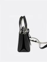 Cartera tipo tote de tamaño compacto, confeccionada en piel sintética lisa color negro. Presenta doble asa de mano ajustable con detalle de hebilla metálica y correa larga ajustable. Incluye cierre principal con cremallera y logo de la marca grabado en la parte inferior frontal.