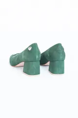 Zapatos de tacón bajo color verde esmeralda, con capellada de gamuza y aplique de cristales en la parte delantera.