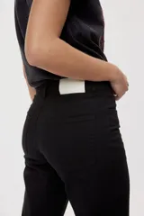 Pantalón de tiro medio y corte wide leg color beige, con diseño clásico de cinco bolsillos, presillas para cinto y cierre frontal con botón y cremallera.