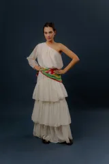 Blusa blanca de un solo hombro con manga larga abullonada y diseño holgado.