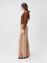 Pantalón de tejido jacquard con textura geométrica en tonos tostado y beige, de tiro medio, cintura elástica con cordón de ajuste y pierna ancha.