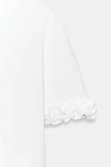 Camiseta de cuello redondo confeccionada en algodón, con mangas cortas decoradas con volantes en el mismo tejido y bajo recto.