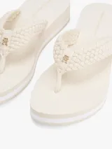 Ojotas Tommy Hilfiger color crema con plataforma baja y tiras tejidas al crochet.