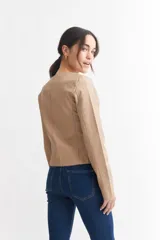 Campera corta color beige con cierre frontal asimétrico y cuello mao.