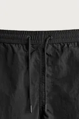 Short de baño de color azul marino, confeccionado en tejido técnico, con cintura elástica ajustable mediante cordón, bolsillos laterales y detalle de bolsillo trasero.