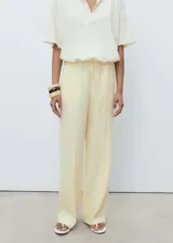 Pantalón de lino color amarillo claro, de corte recto y tiro medio, con cintura elástica ajustable con lazo.