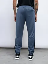 Pantalón de jogging Umbro confeccionado en poliéster, con diseño de bloques de color en azul y negro, cintura elástica con cordón ajustable y puños en los tobillos.