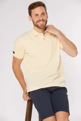 Remera polo lisa color amarillo pastel, confeccionada en piqué Oxford, con cuello en rib y botones personalizados.