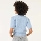 Sweater de punto de textura suave, color azul claro, con cuello redondo y mangas cortas. Presenta un diseño de corte recto con terminaciones acanaladas en cuello, mangas y ruedo.