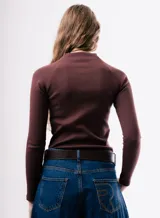 Camiseta de ajuste entallado, color bordó, con cuello alto y mangas largas.