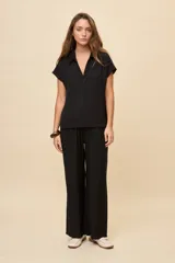 Pantalón gris de corte amplio y silueta fluida, con cintura elástica y cordón ajustable.