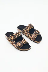 Sandalia tipo birkenstock de pelo con estampado animal print (leopardo), con dos tiras ajustables y tachas metálicas negras. La plantilla es de corcho y la suela de goma eva.