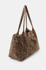 Maxi bolsa de algodón con estampado animal print, diseño rectangular con asas de hombro y bolsillos laterales.
