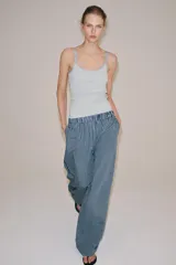 Pantalón de tiro medio con pierna ancha y cintura elástica, confeccionado en mezcla de viscosa con diseño de rayas verticales en tonos mostaza y marrón.