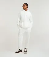 Pantalón jogger blanco de algodón y poliéster, con cintura elástica y cordón ajustable. Presenta un corte holgado con puños ajustados en los tobillos.