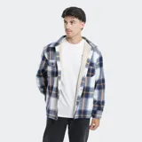 Camisa de franela a cuadros en tonos grises, blancos y negros, forrada con corderito sintético en el interior. Cuenta con mangas largas, bolsillos con solapa en el pecho y cierre frontal con botones.