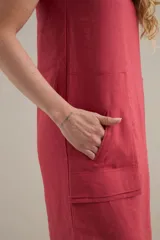 Vestido midi de lino color rojo coral, de silueta relajada y diseño minimalista, con escote redondo, sisas amplias y bolsillos delanteros aplicados con solapa.